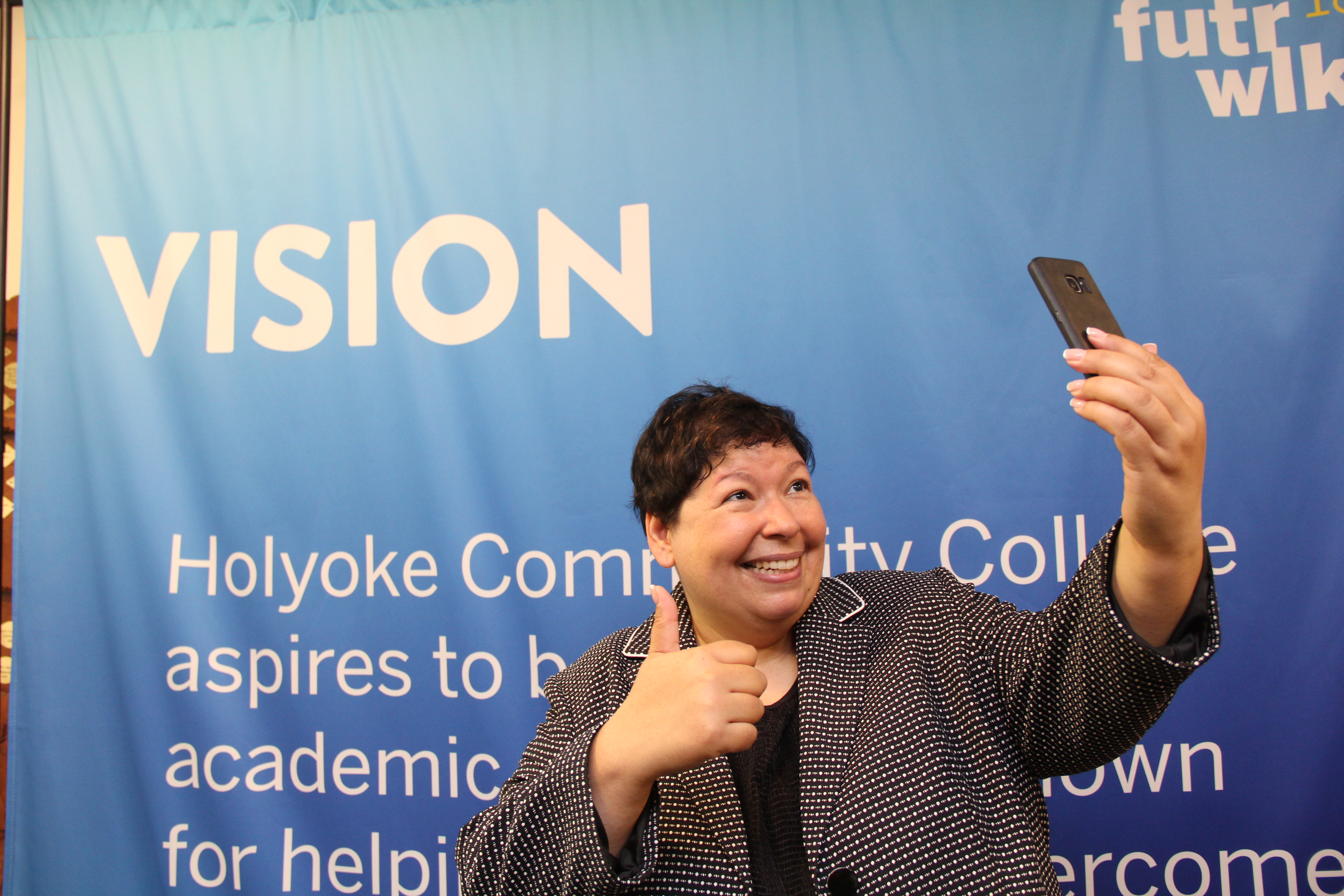 Christina Royal takes a selfie in front of a vision poster